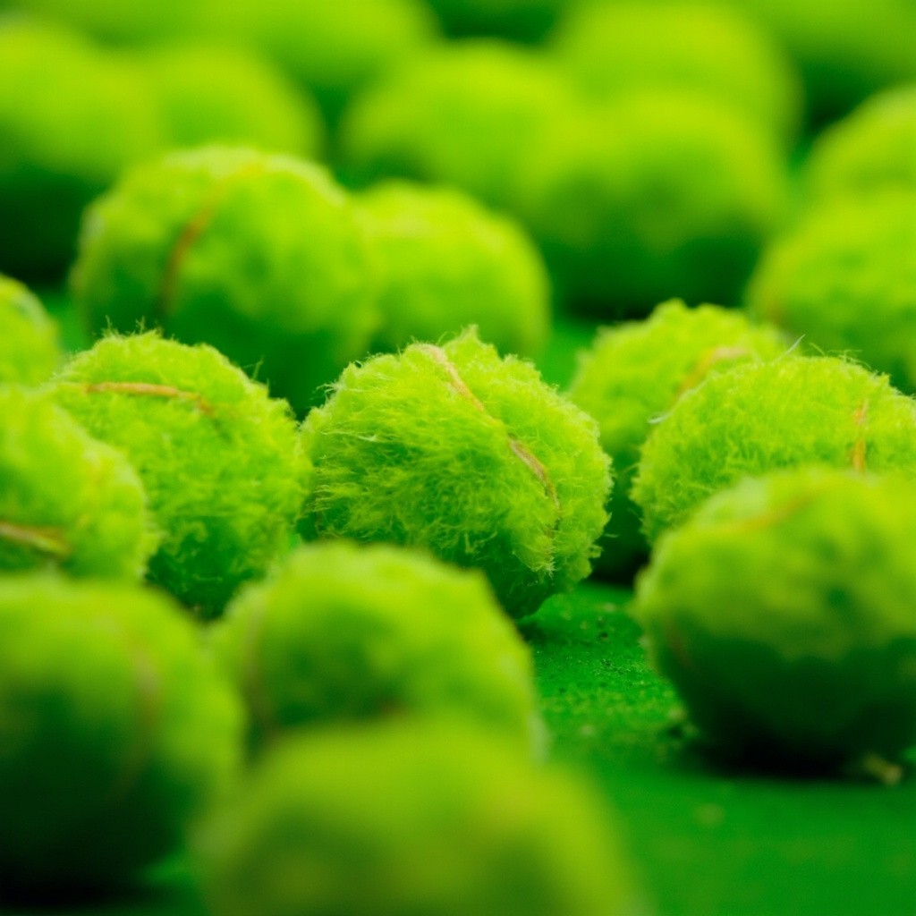 A Close-Up View of Green Tennis Balls on Court