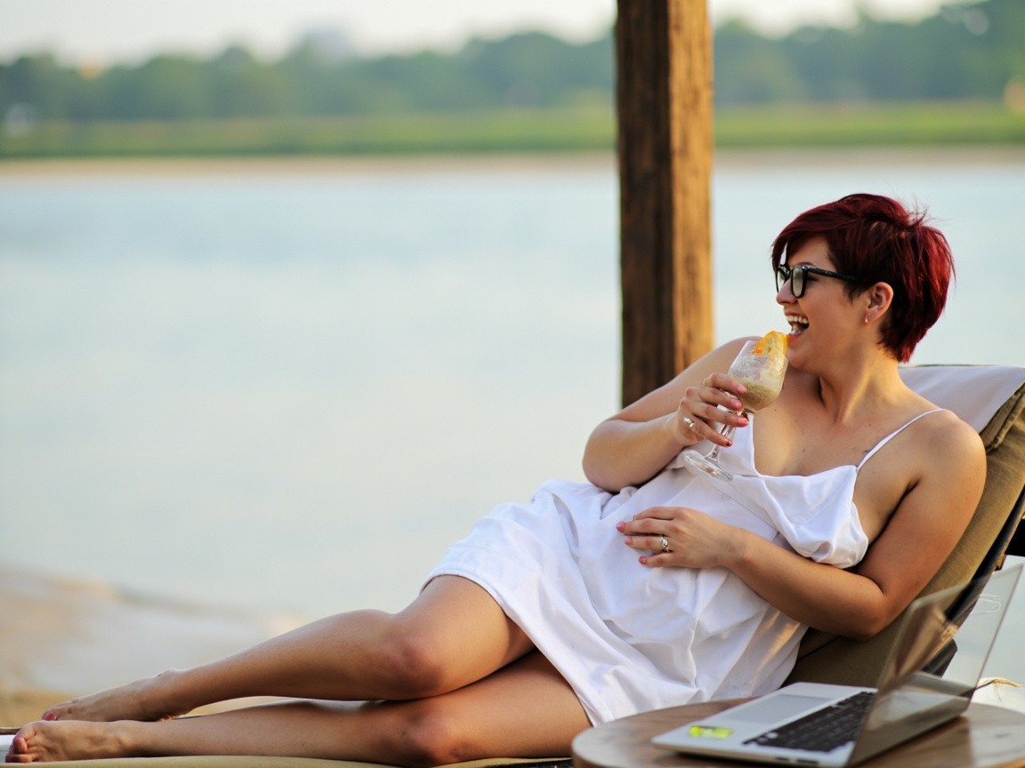 A Girl Relaxing by the River with Laptop