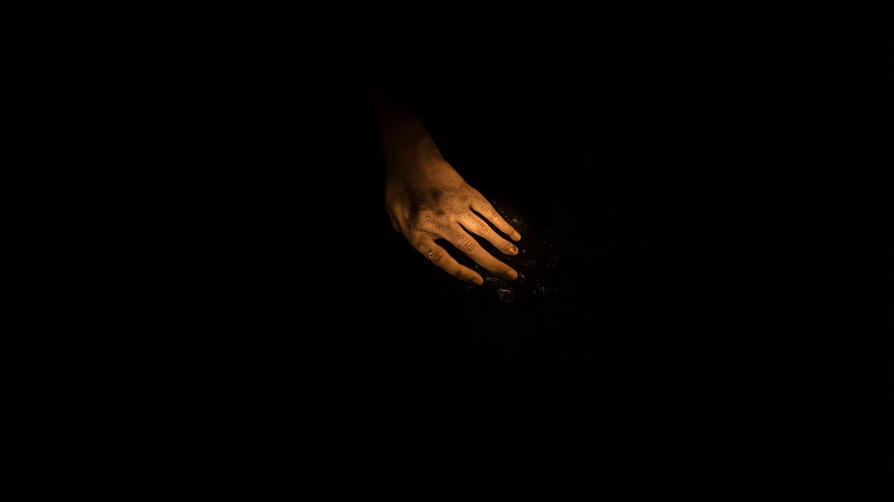 A Golden Hand Against a Black Background