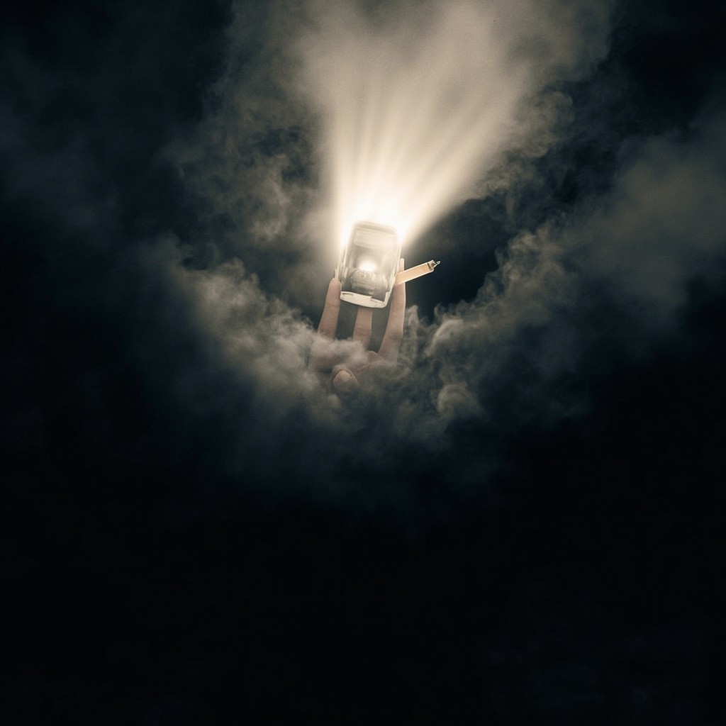 A Hand Pushing Away Smoke in Darkness