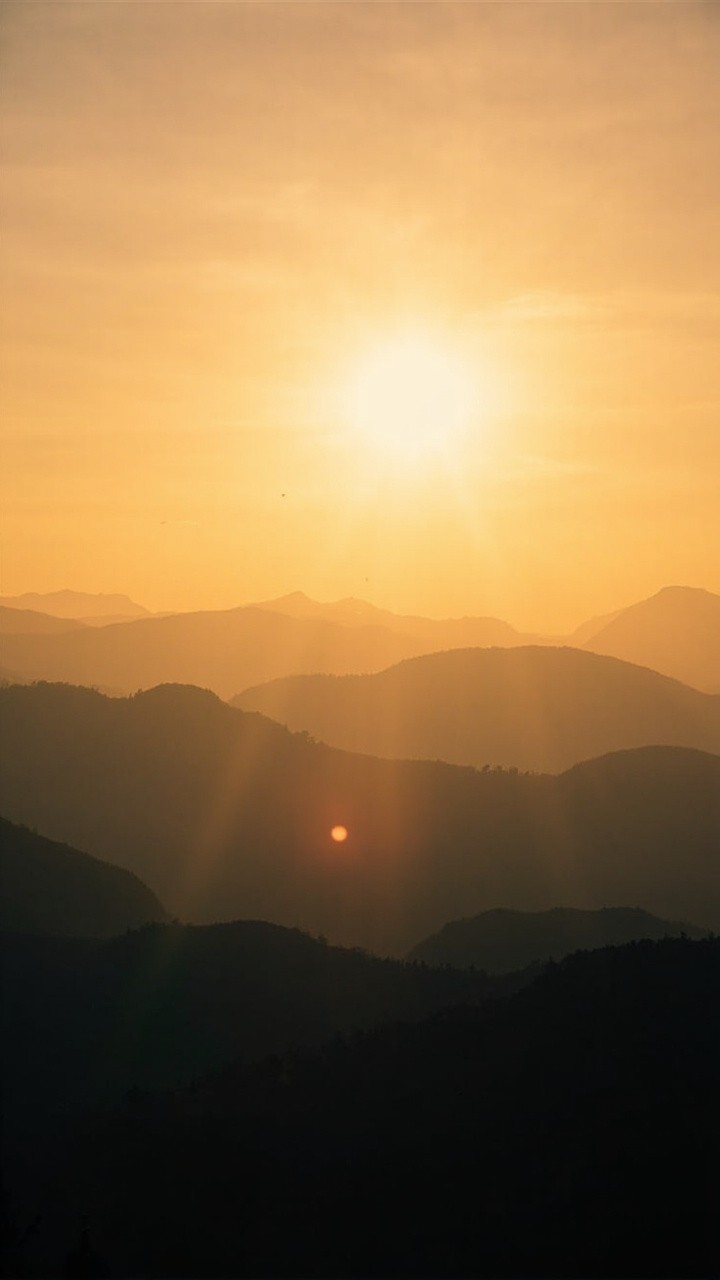 A Hopeful Sunrise Over Calm, Misty Mountains