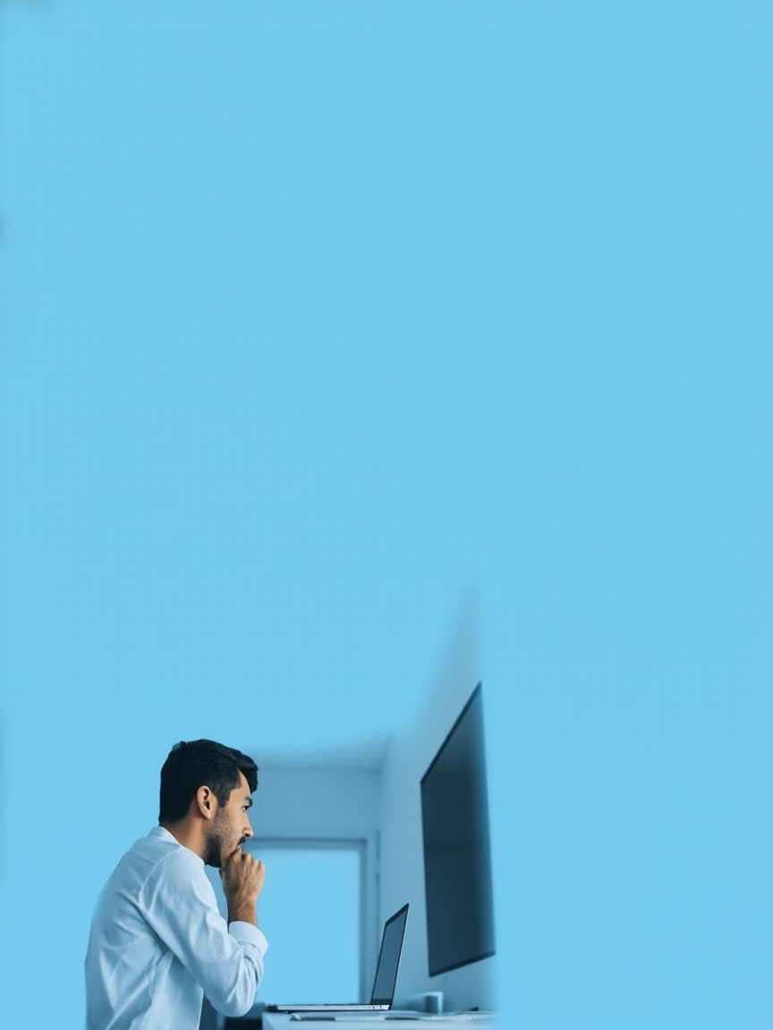Man Working on Laptop Against Light Blue Background