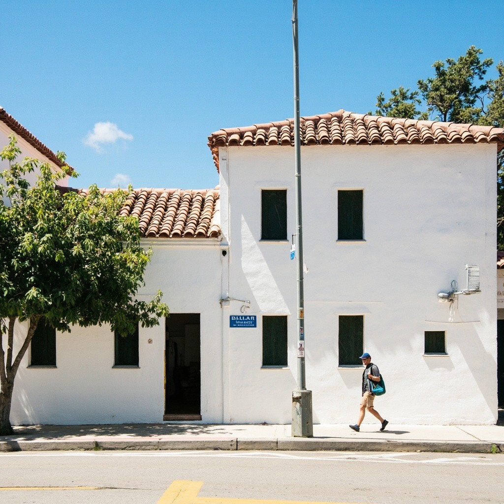 Walking Past a Sunny Spanish Stucco Building